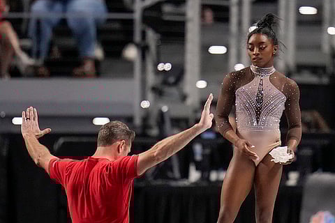 Simone Biles listens to her coach Laurent Landi